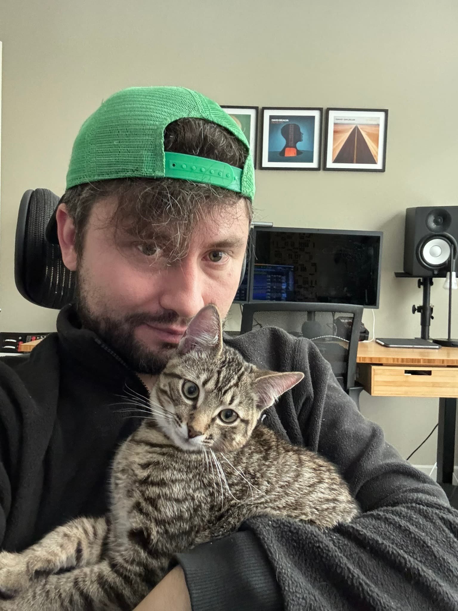David Grijalva at his workspace holding his cat
